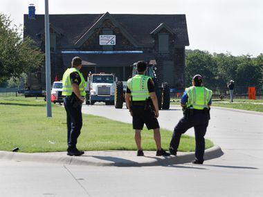 Three Plano police officers watch as the Collinwood Home, built around 1861, is moved West...