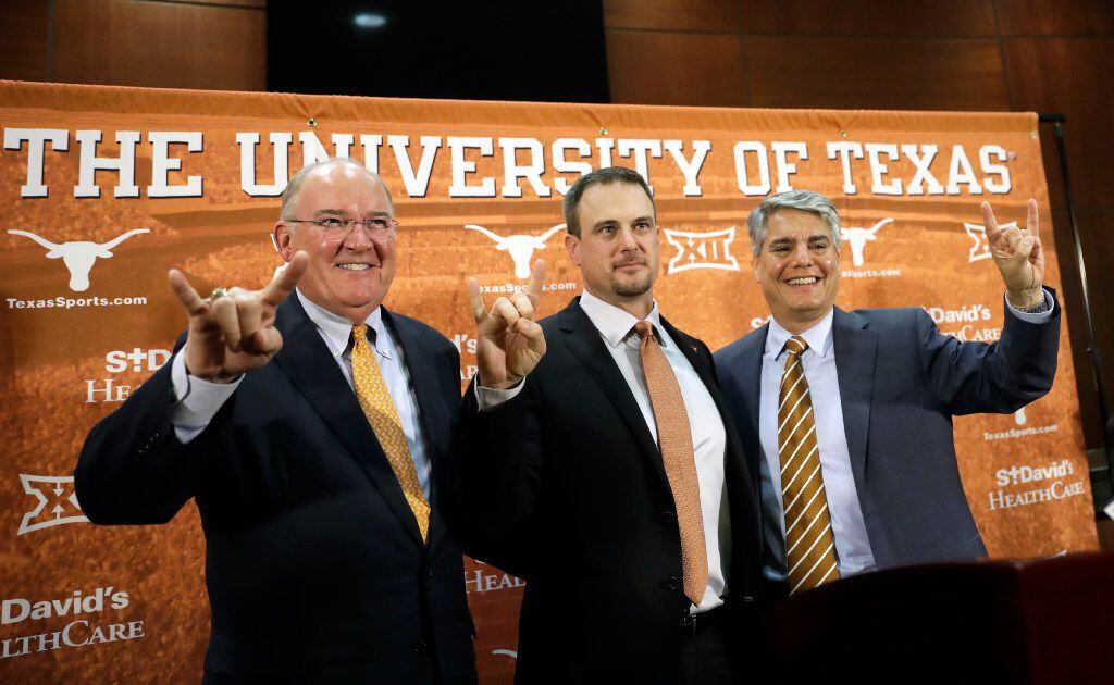 Tom Herman, center, poses with athletic director Mike Perrin, left, and school president...