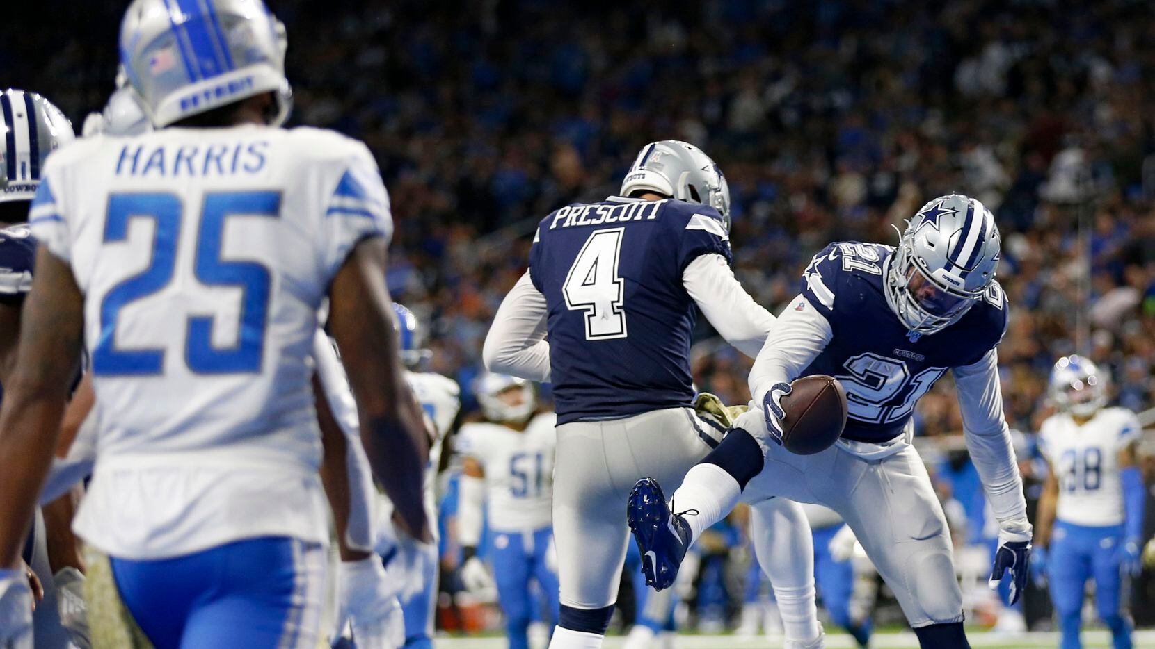 Dallas Cowboys running back Ezekiel Elliott (21) and Dallas Cowboys quarterback Dak Prescott (4) celebrate after Elliott scored a touchdown during the second half of play at Ford Field in Detroit, on Sunday, November 17, 2019. Dallas Cowboys defeated the Detroit Lions 35-27. (Vernon Bryant/The Dallas Morning News)
