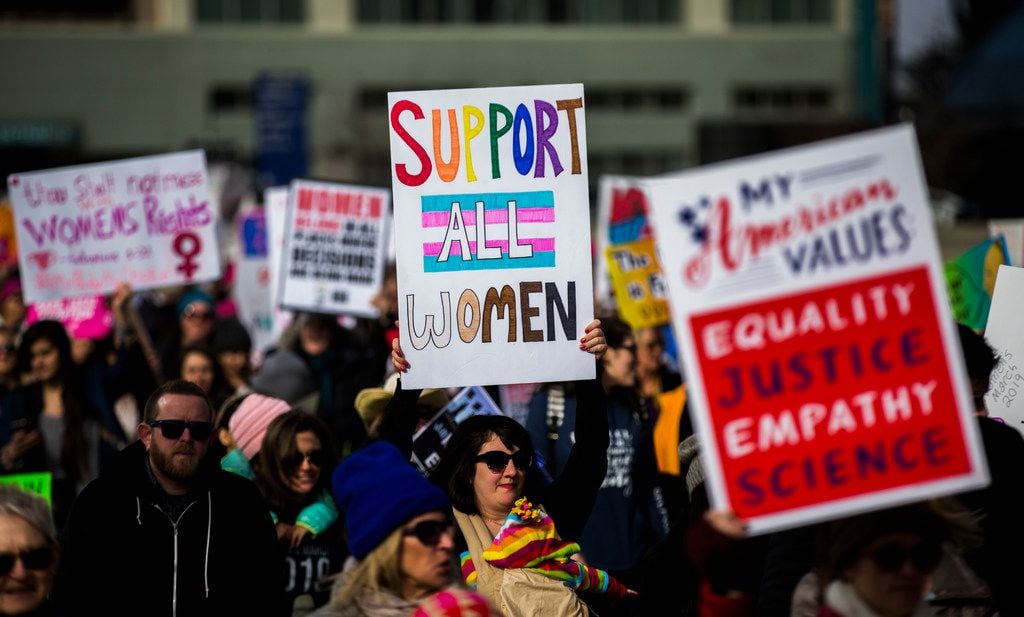 Demonstrators hold up signs during the Dallas Women's March on Sunday, January 20, 2019, in...