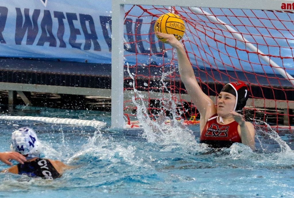 Flower Mound Marcus high school goalie Emily Engberson, right, tries to block a shot as...