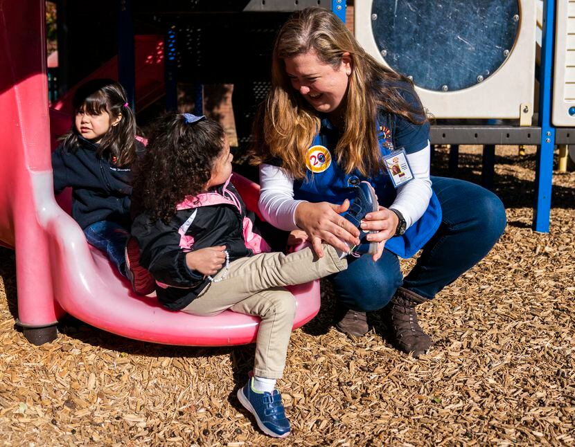 Teacher Alecia Gonzalez helps Maria Rodriguez, 3, with her shoe on the playground on Nov....