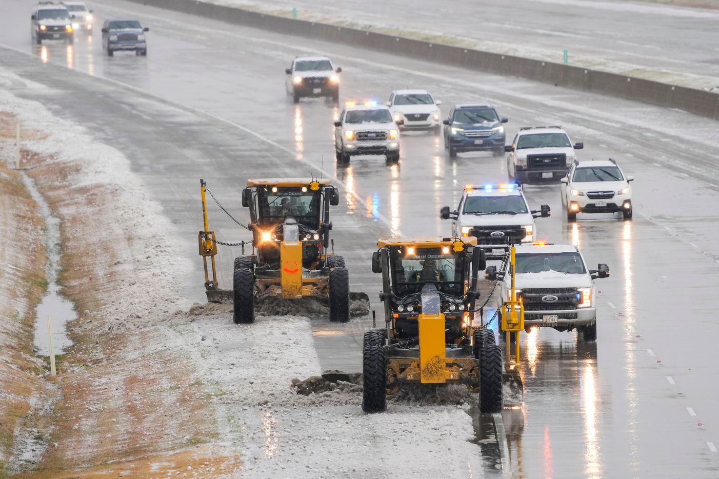 Crews clear ice from the Bush Turnpike near Preston Road on Wednesday, Feb. 1, 2023, in...