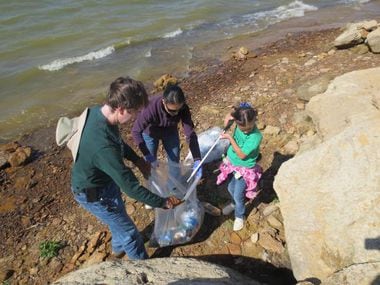 Volunteers gather trash near a lake. Irving is recruiting volunteers for its annual Trash-Off on April 10.