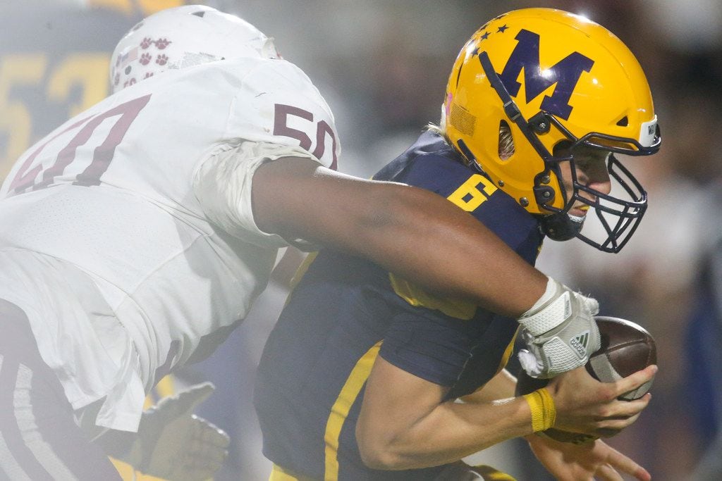 McKinney quarterback gets sacked by Plano defensive lineman Devid Smith (50) during the...