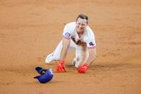 Texas Rangers' Wyatt Langford trips as he rounds second base during the second inning of a...