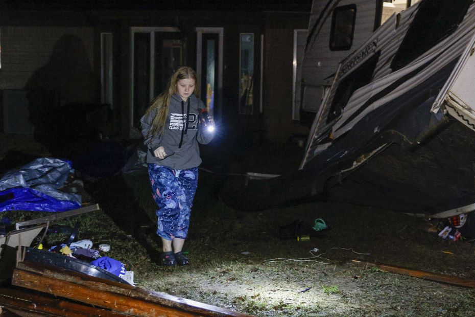 Brittaney Deaton, 17, searches through her scattered belongings after a possible tornado...