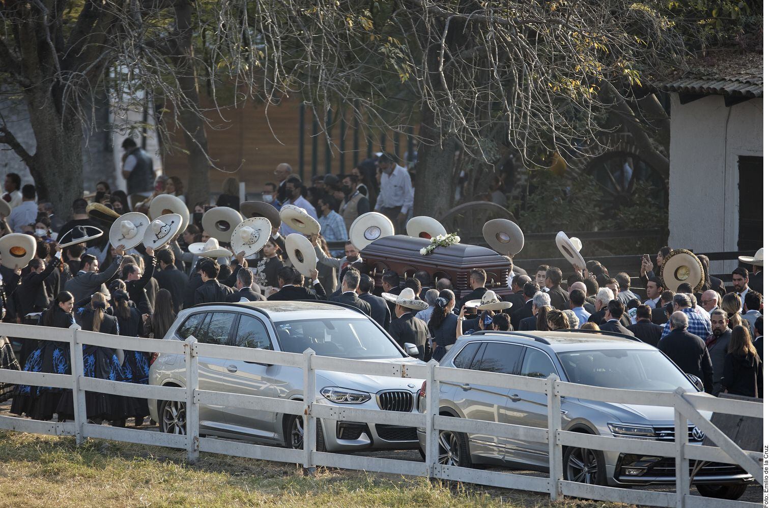 El cuerpo de Vicente Fernández pasa rumbo a su destino final, mientras sus allegados, muchos ataviados de charros, levantan sus sombreros.