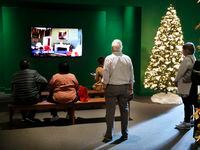Visitors view a video of the Christmas decorated White House in 2007 during the Holiday in...