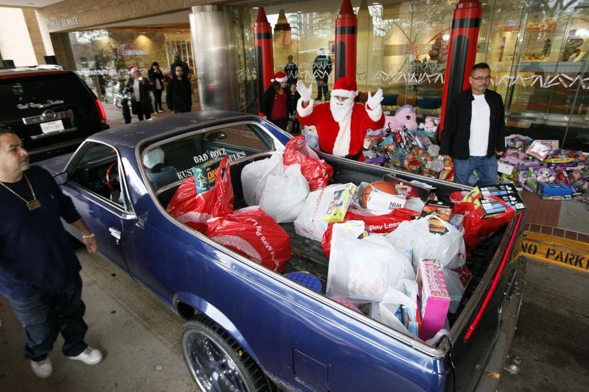 Jimmy López, vestido como Santa Claus, recibe un auto El Camino con la caja llena de...