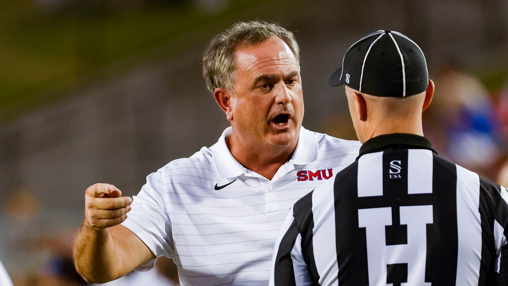 SMU head coach Sonny Dykes talks to refs as they review Southern Methodist Mustangs running...