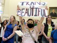 Callie Butcher of Dallas, left in blue, stands with Nova Meis-Strub, holding sign, in the...