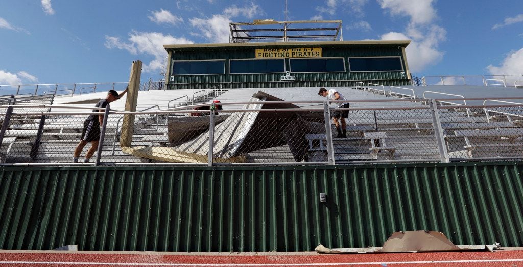 Students at Rockport-Fulton High School help clear debris from the football field that was...