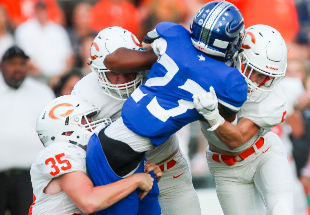 Nolan Catholic running back Sergio Snider (23) gets tackled by a herd of Celina defenders...