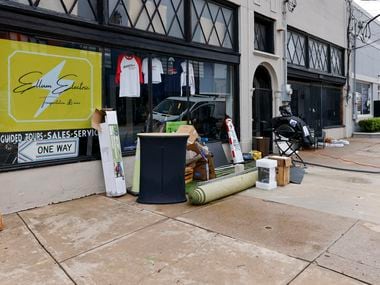 Flood damaged items and carpeting sit along the sidewalk outside of Ellum Electric, an...