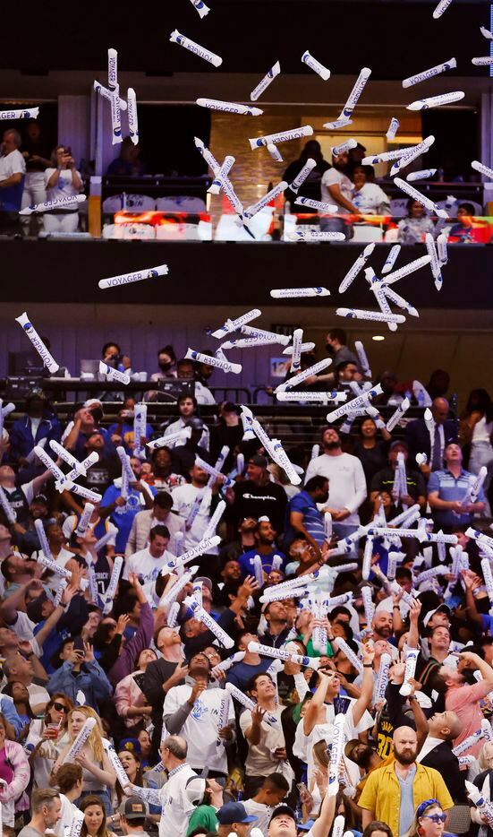 Dallas Mavericks fans reach for thunder sticks dropped from the rafters before their game...