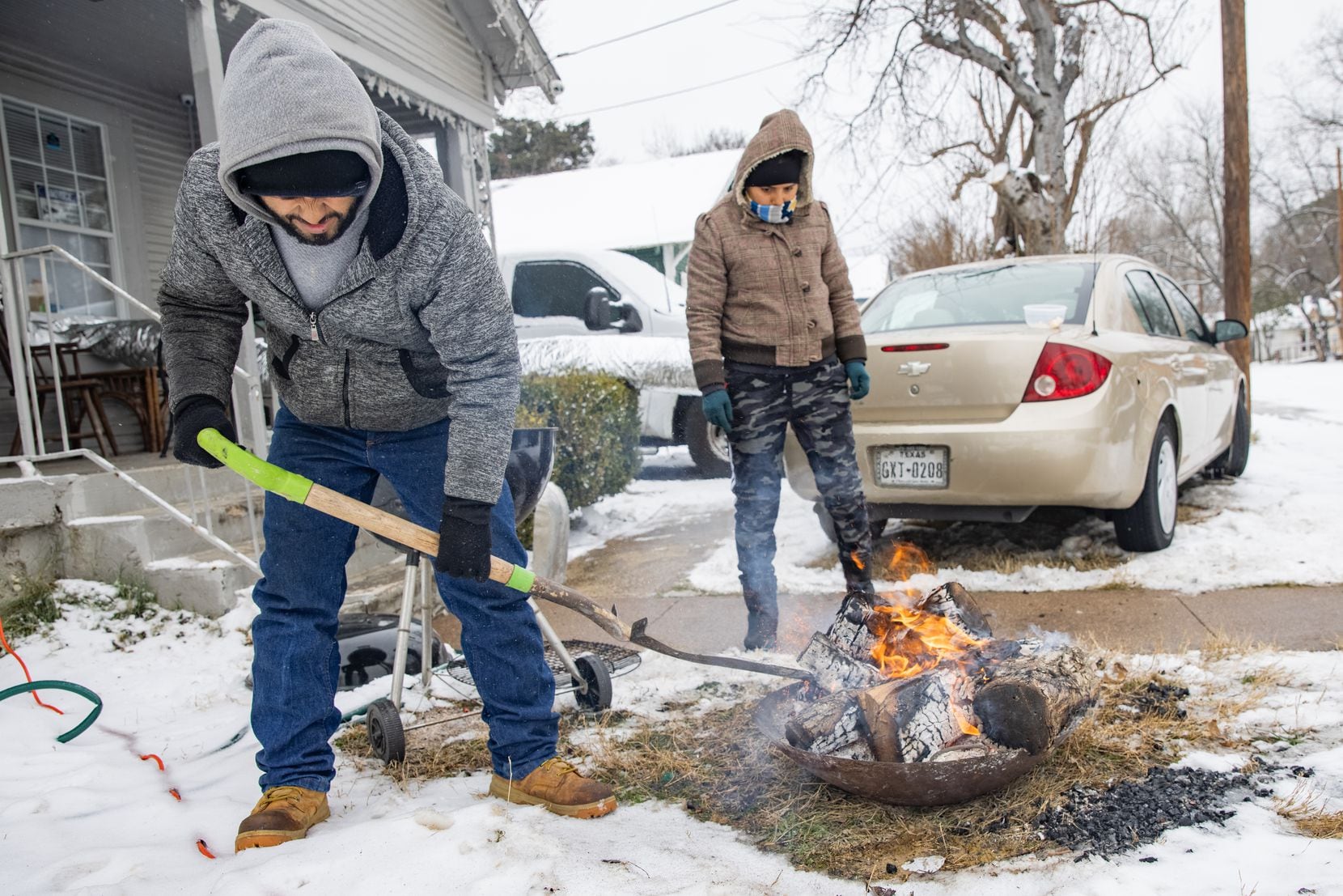 Leonel Solis (left) and Estefani Garcia get ready to cook outside of their home in East...