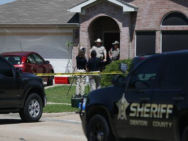 Law enforcement officers and crime scene technicians investigate at a home where five people...