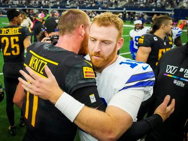 Dallas Cowboys quarterback Cooper Rush (10) hugs Washington Commanders quarterback Carson...