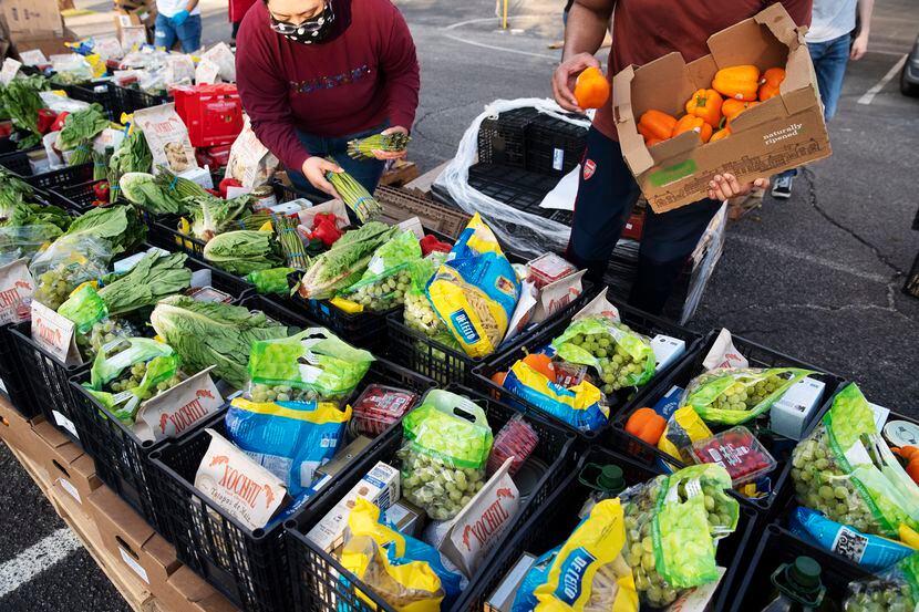 Voluntarios ayuda a empacar despensas de comida para familias indocumentadas a través de...