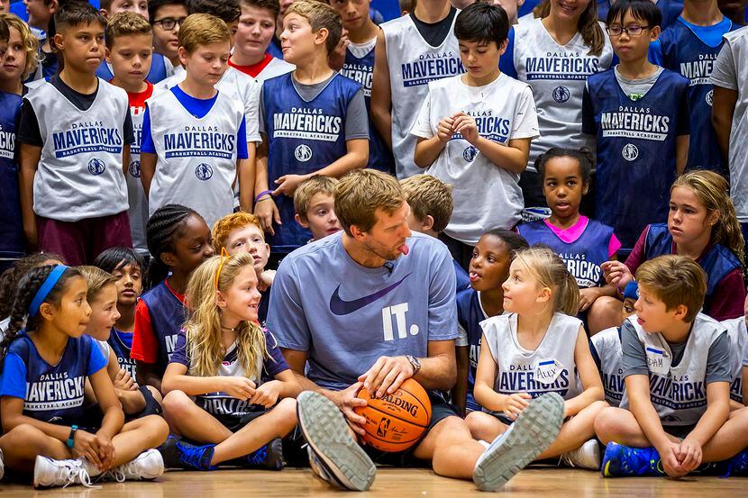 Dirk Nowitzki bromea con una niña durante una foto grupal en el Mavericks Summer Hoop Camp...