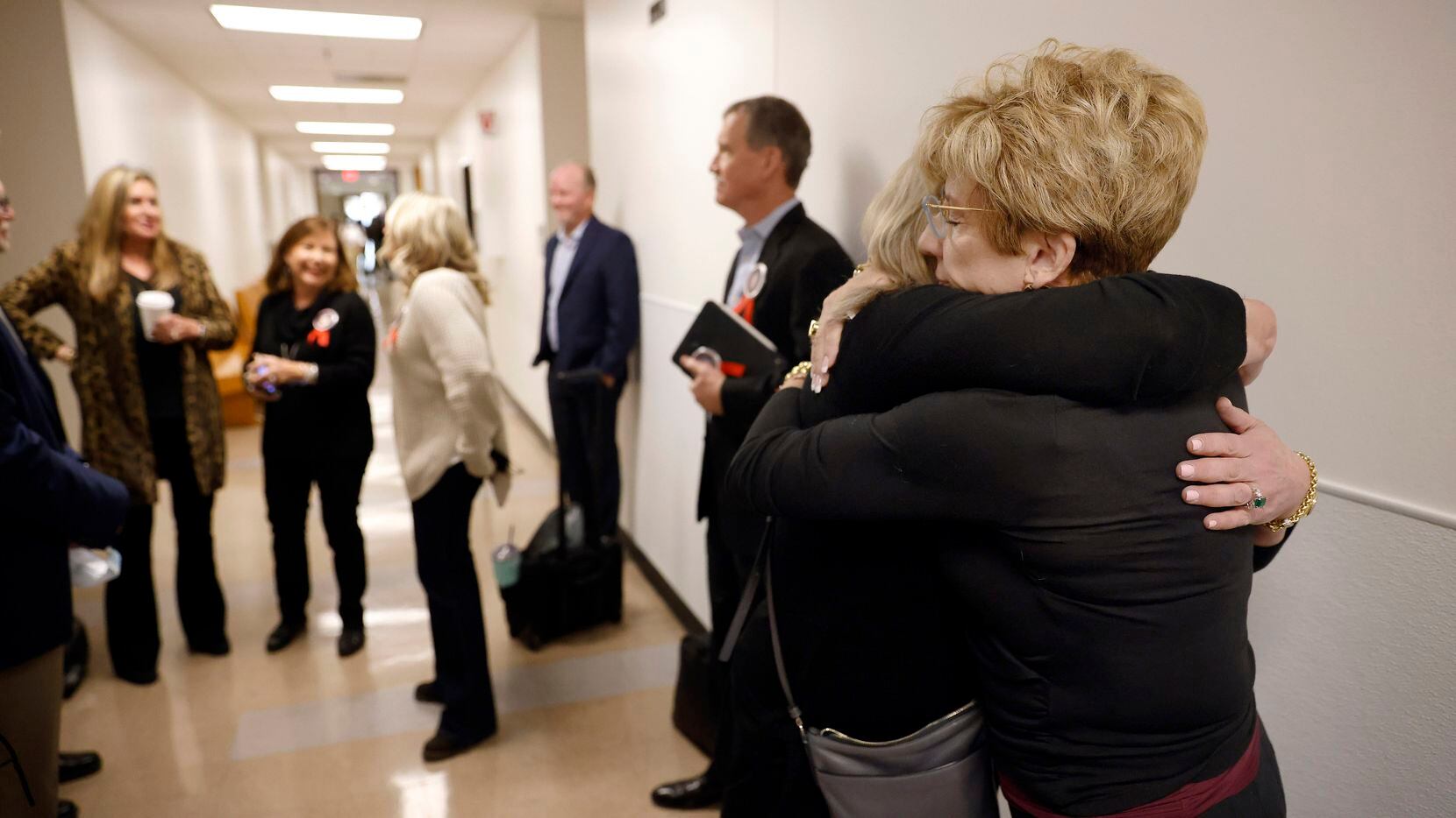 Shannon Dion (right), daughter of Doris Gleason, receives a hug as victims families gathered...