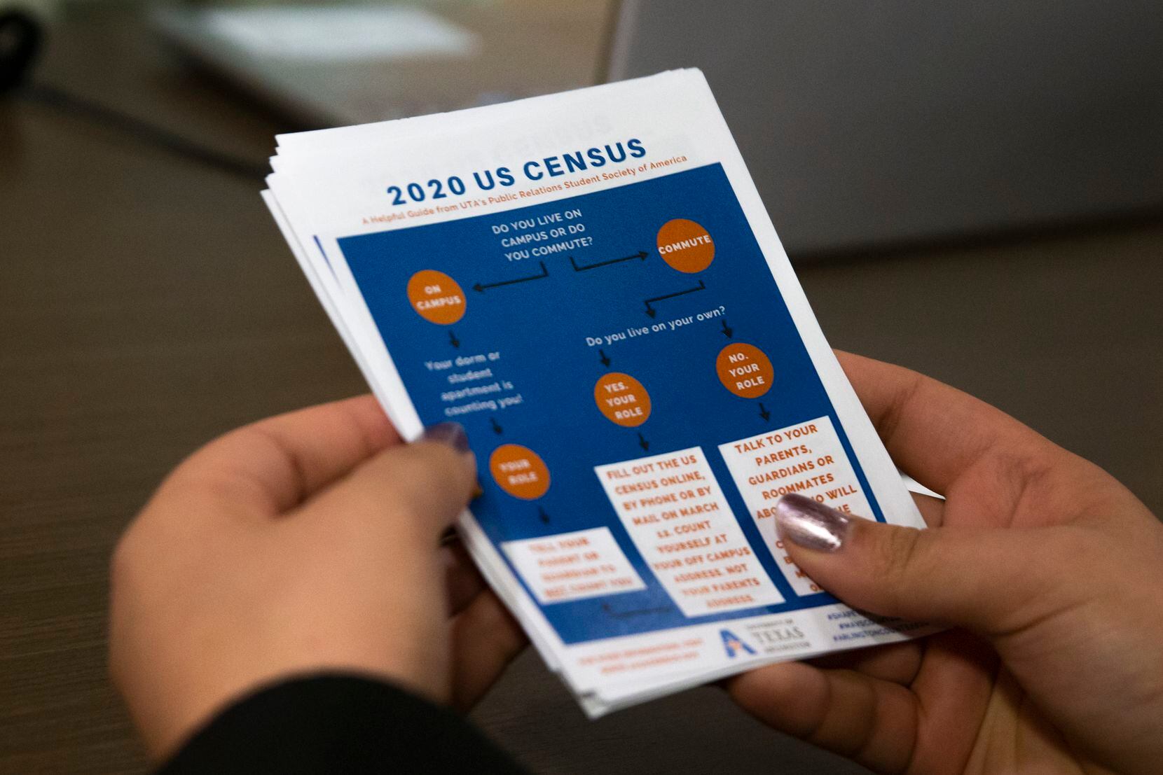 Herminia Becerra, junior, holds a stack of census flyers while surveying students in the...