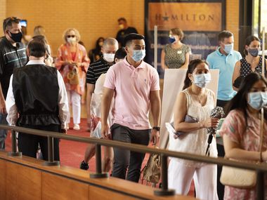 Vuong To (center), 21, wearing a face mask, walked into the Music Hall at Fair Park in Dallas with his family to see a dress rehearsal of "Wicked," hosted by Dallas Summer Musicals, on Aug. 01, 2021.