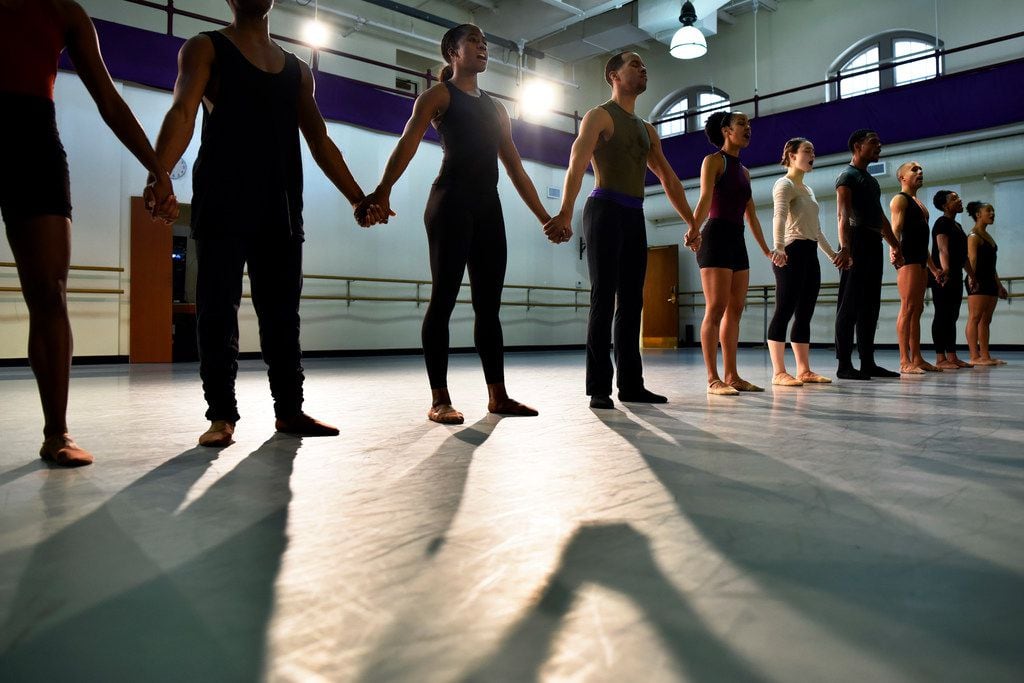 Dallas Black Dance Theatre company members hold hands during the opening moments of a...