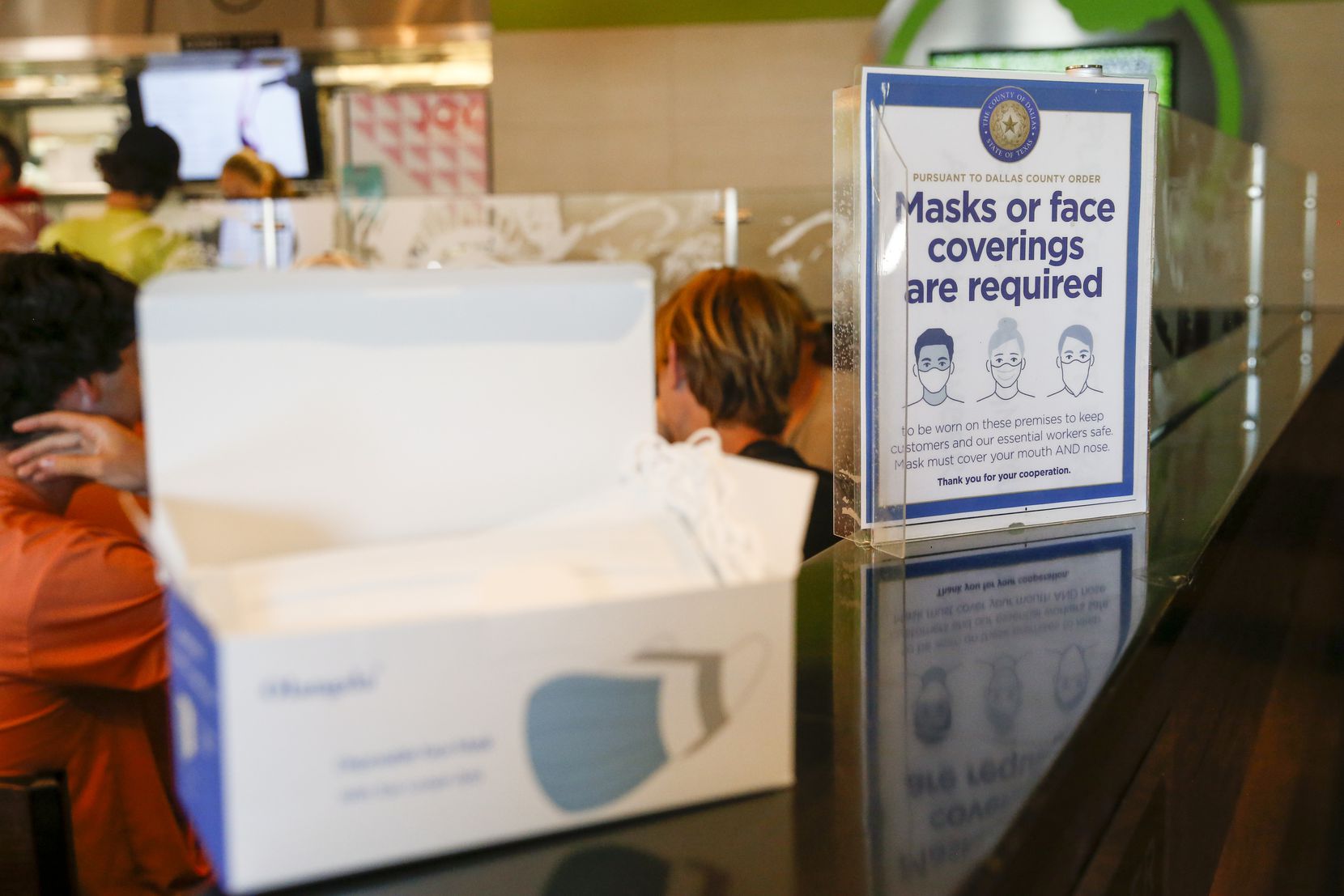 A sign informs customers that masks are required at Liberty Burger on Thursday, Aug. 12, 2021, in Dallas. Masks are required in schools and businesses after a new executive order from Dallas County Judge Clay Jenkins. 
