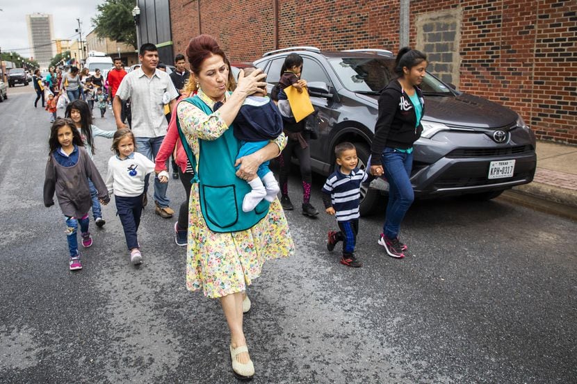 La voluntaria Blanca Muñoz lleva un bebé mientras transporta a un grupo de indocumentados a...