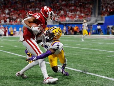 ATLANTA, GEORGIA - DECEMBER 28: Wide receiver Charleston Rambo #14 of the Oklahoma Sooners is tackled by cornerback Woodi Washington #5 of the Oklahoma Sooners during the Chick-fil-A Peach Bowl at Mercedes-Benz Stadium on December 28, 2019 in Atlanta, Georgia. (Photo by Kevin C. Cox/Getty Images)