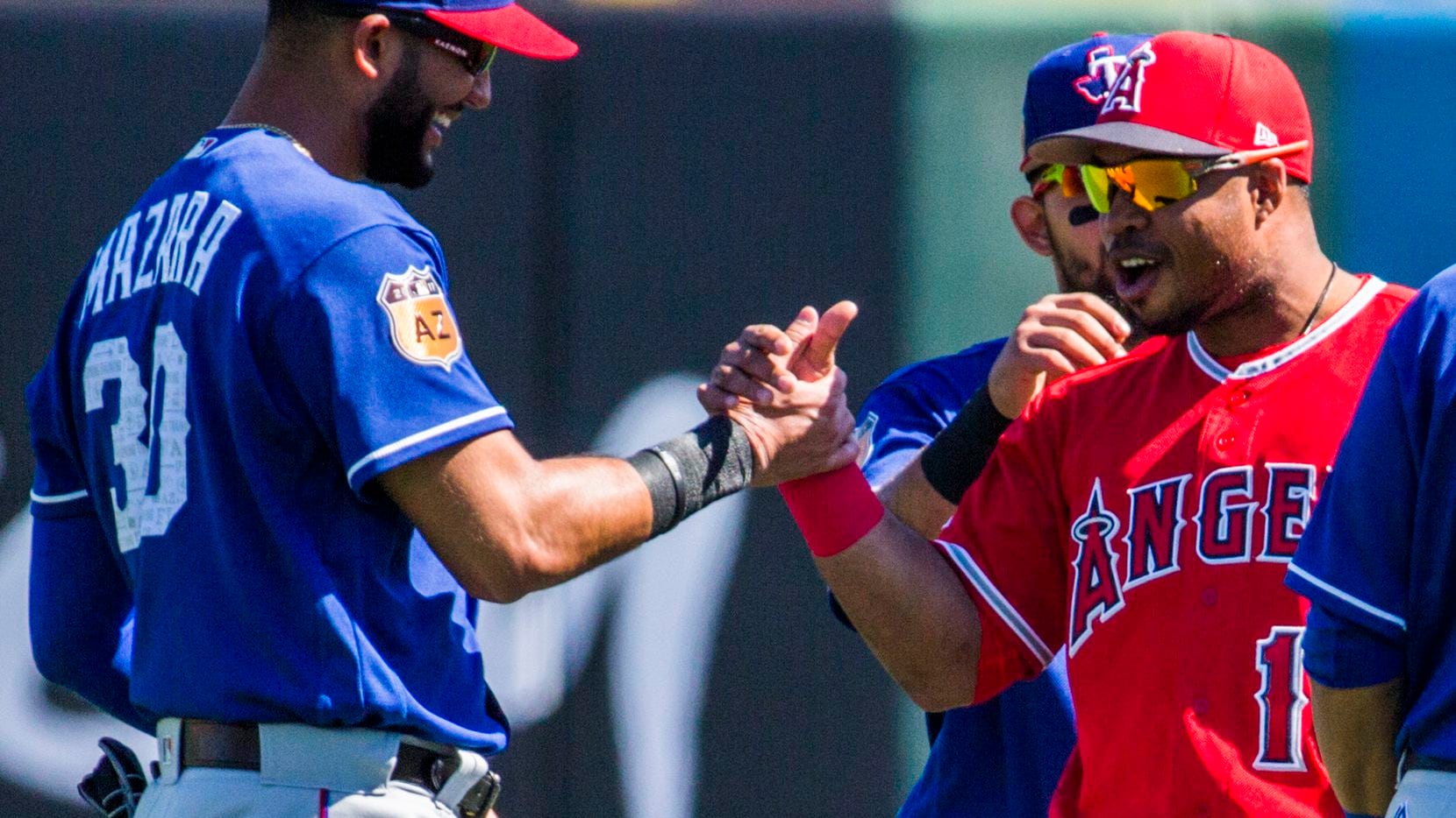 Texas Rangers right fielder Nomar Mazara (30) greets Los Angeles Angels third baseman Luis...
