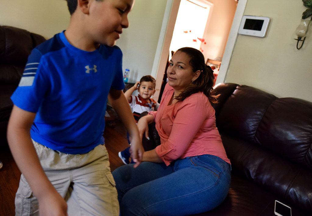 Marta Hernandez relaxes as her son Kenneth plays at his grandparents' home in Irving. 