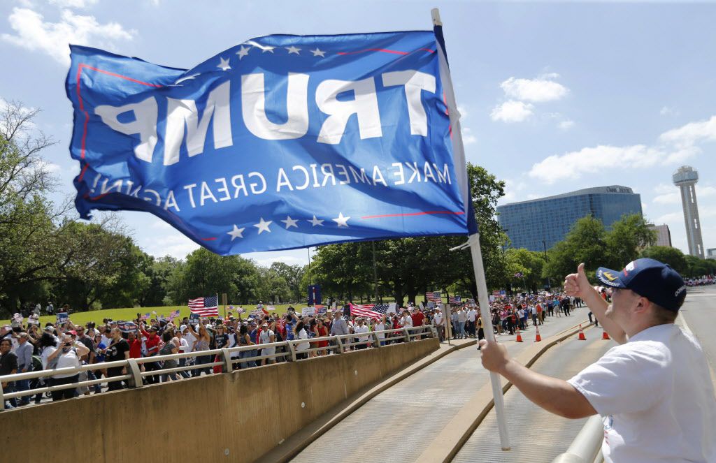 Trump supporter Dustin Marvin of Dallas posts up across the street as people march towards Dallas City Hall during the Mega March in Dallas on Sunday, April 9, 2017. (Vernon Bryant/The Dallas Morning News)