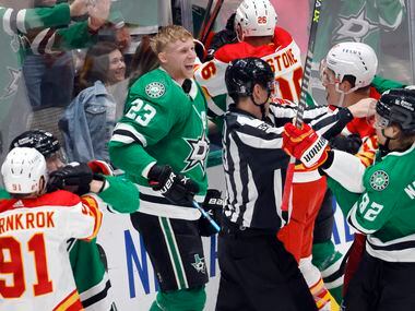 Dallas Stars defenseman Esa Lindell (23) laughs at Calgary Flames defenseman Nikita Zadorov...