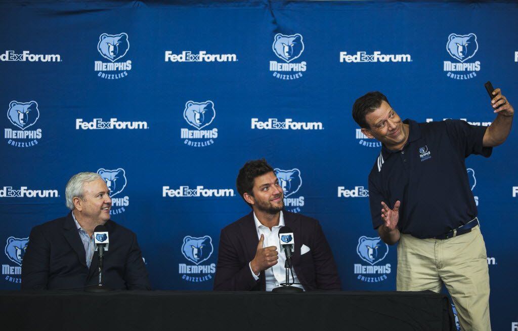 Memphis Grizzlies general manager Chris Wallace, left, watches new Grizzlies player Chandler Parsons, center, has his photo taken with Grizzlies TV sideline reporter Rob Fischer during a news conference Friday, July 8, 2016, in Memphis, Tenn. (Yalonda M. James/The Commercial Appeal via AP)