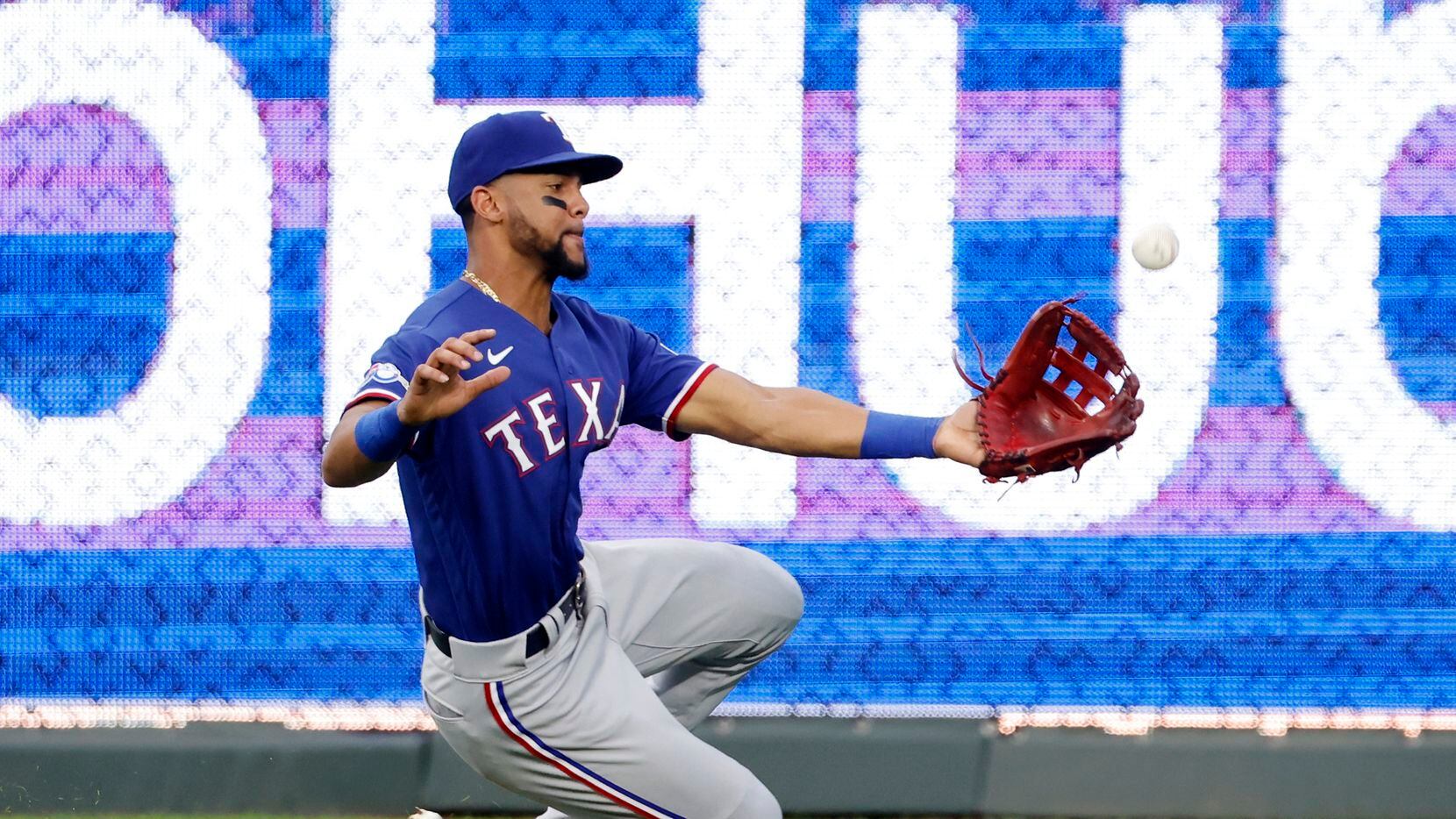 Texas Rangers center fielder Leody Taveras is unable to catch a hit by Kansas City Royals'...