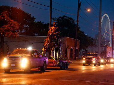The Robert E. Lee statue is given a police escort after its removal from a public park in...