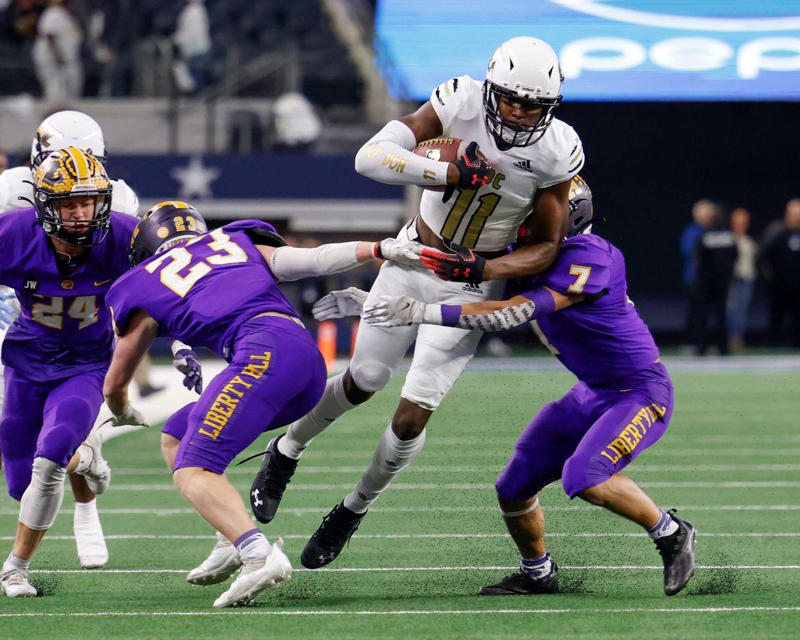 South Oak Cliff wide receiver Jamyri Cauley (11) jumps through the arms of Liberty Hill linebacker Devin Riley (7) and Liberty Hill defensive back Carlton Schrank (23) during the first quarter of their Class 5A Division II state championship game at AT&T Stadium in Arlington, Saturday, Dec. 18, 2021. (Elias Valverde II/The Dallas Morning News)