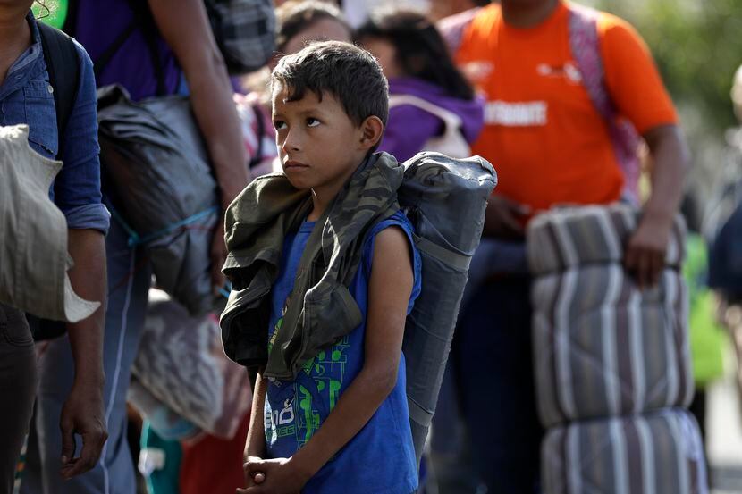 Daniel Gamez, un niño hondureño, hace fila junto a su familia en espera de alimentos en...