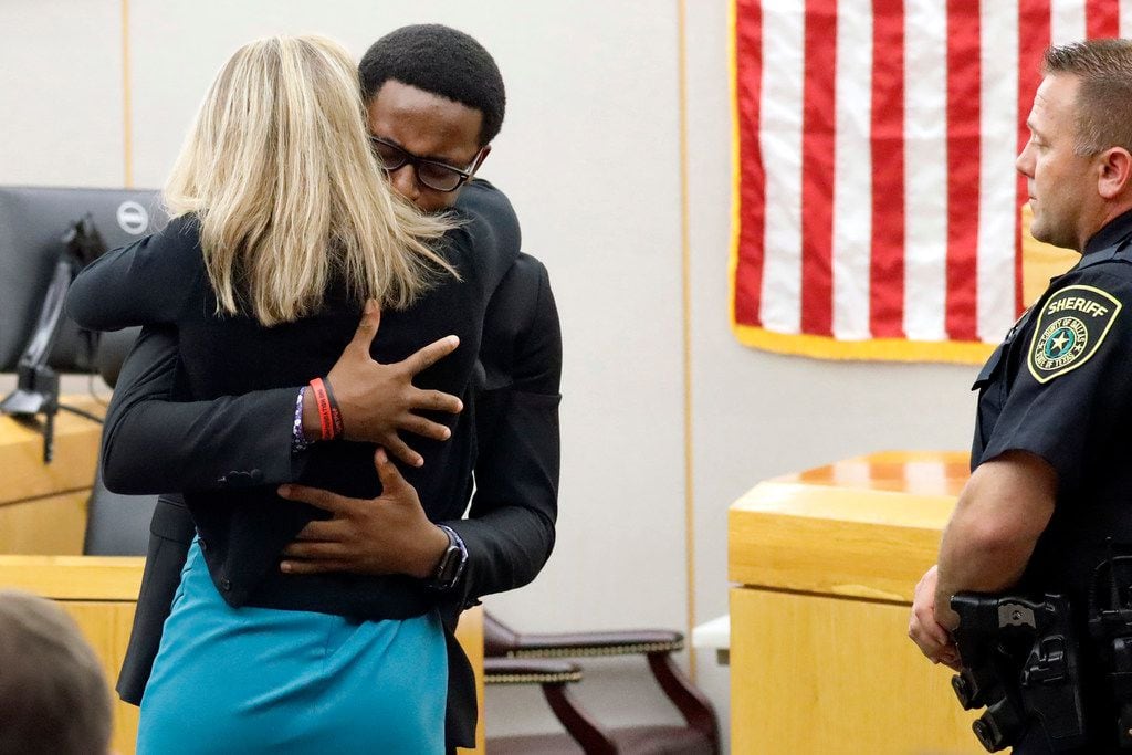 Brandt Jean hugs Amber Guyger in the courtroom Wednesday after saying he had forgiven her...