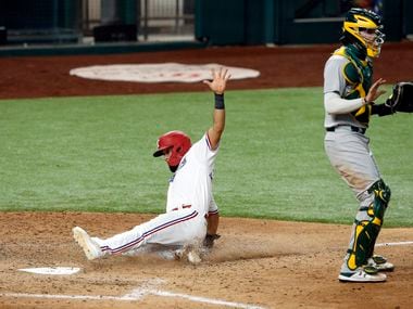 Texas Rangers Isiah Kiner-Falefa (9) slides across home plate scoring on a two-run single by Nick Solak in the fifth inning against the Oakland Athletics at Globe Life Field in Arlington, Texas,Tuesday, August 25, 2020. Oakland Athletics catcher Jonah Heim (37) calls off the throw home.