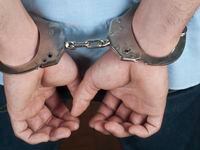 A man's hands in handcuffs behind his back.