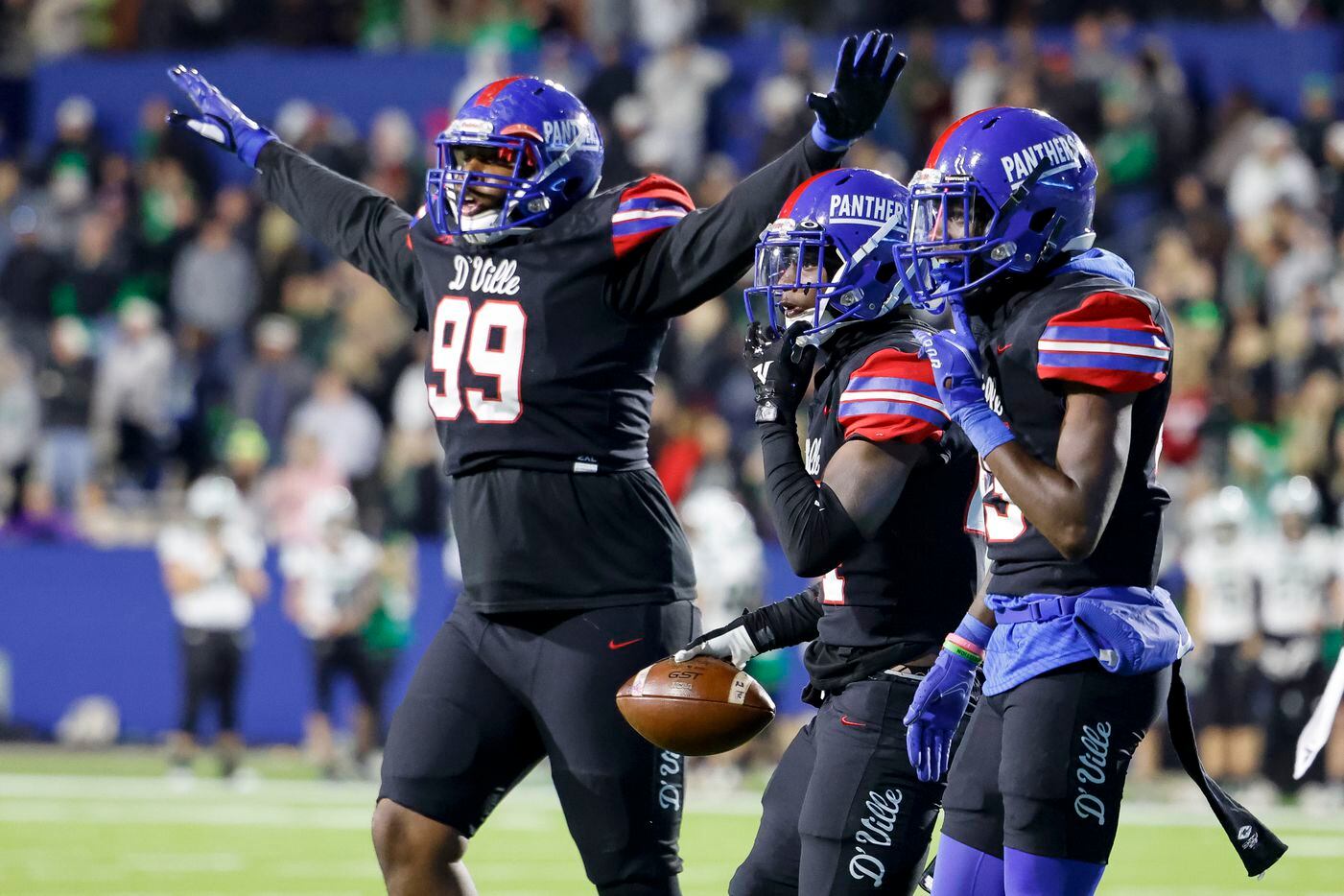Duncanville defensive lineman Kelson English (99), defensive back Cole Carter (24) and defensive back Sam Roberts (15) celebrate an interception by Carter during the second half of their Class 6A Division I state semifinal playoff game against Southlake Carroll at McKinney ISD Stadium in McKinney, Texas, Saturday, Dec. 11, 2021. Duncanville defeated Southlake Carroll 35-9. (Elias Valverde II/The Dallas Morning News)