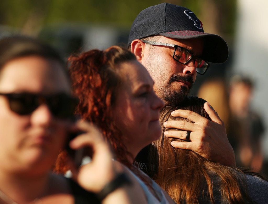 William Hunter embraces his daughter Destiny Hunter, who is home schooled, during a vigil...