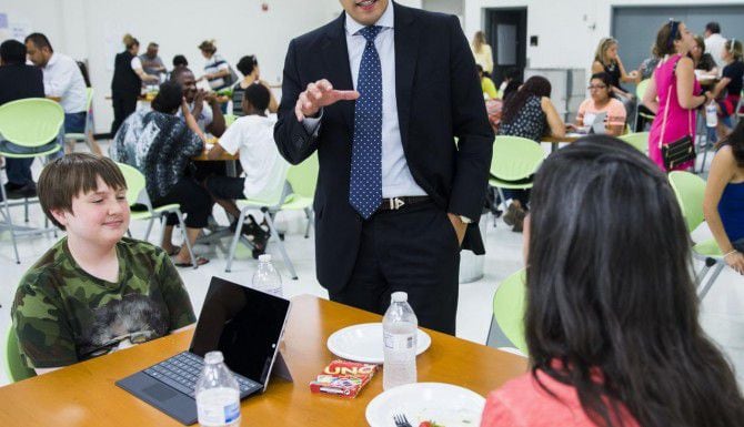 El presidente de la junta escolar de Dallas Miguel Solís habla con un par de alumnos de la...