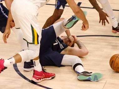Dallas Mavericks guard Luka Doncic (77) falls after getting hit in the face by Utah Jazz...