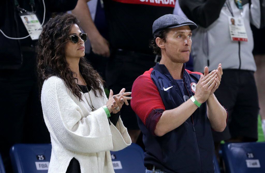 Actor Matthew McConaughey and his wife Camila Alves watch a basketball game between the...