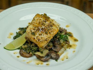 A Pan Seared Sea Bass arocet with compound butter, served atop sauteed Bok Choy and Shitake...
